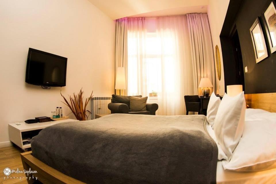 a bedroom with a large bed and a tv at Ivana Apart Hotel in Oradea