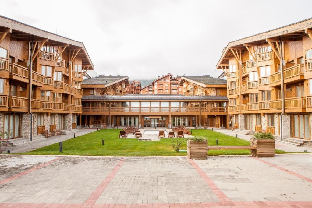 a large building with a courtyard in front of it at Pirin Golf Hotel Private Apartments Апартаменти Планински Изгрев в Пирин Голф in Razlog