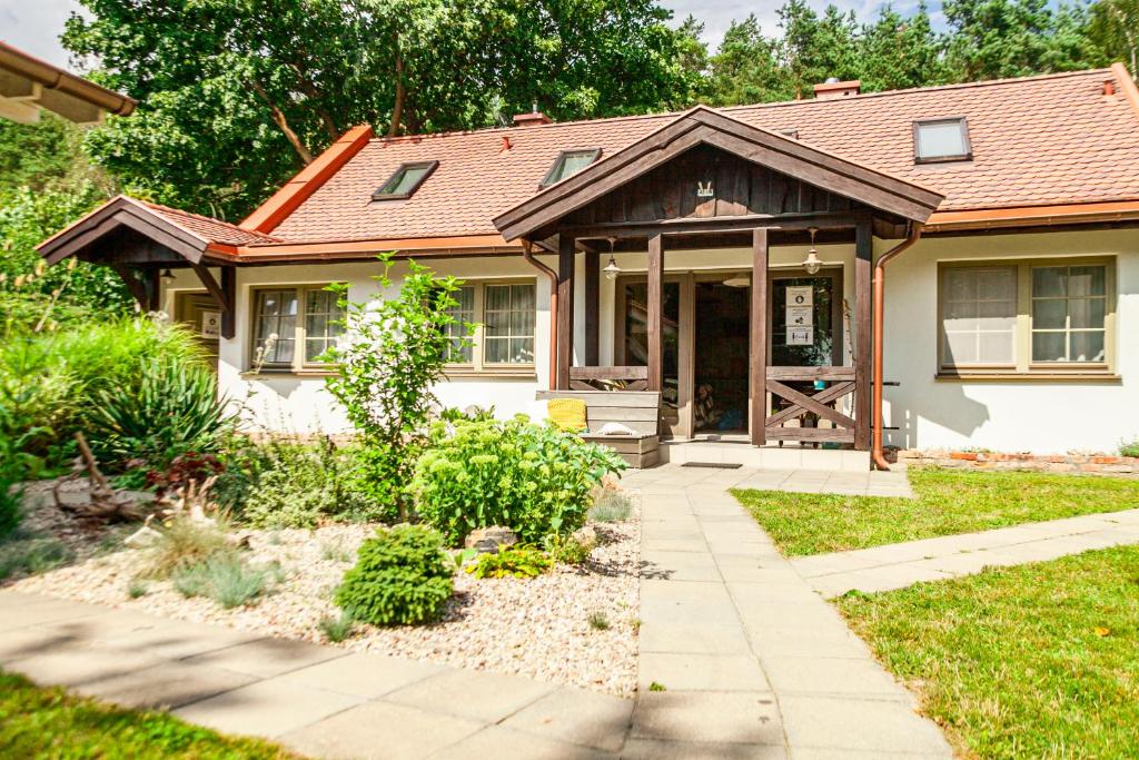 Cette petite maison dispose d'une terrasse couverte et d'une porte. dans l'établissement Domek pod Grabami, à Gdańsk