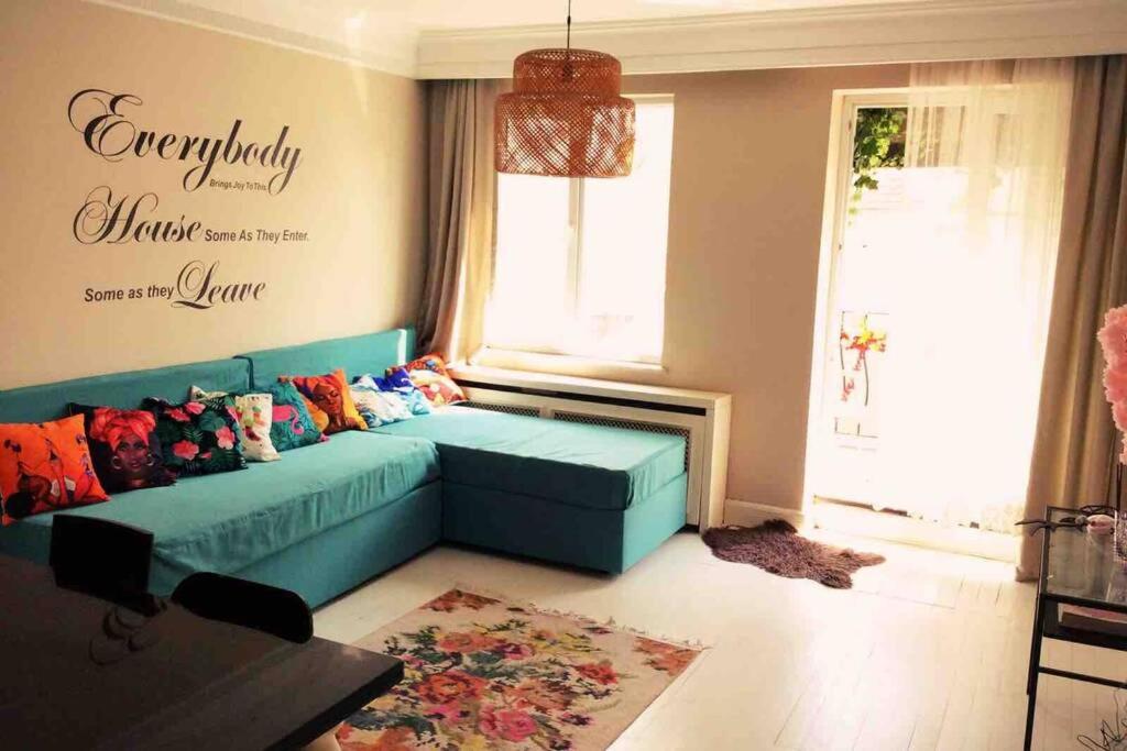 ein Wohnzimmer mit einem blauen Sofa und einem Fenster in der Unterkunft Balcony&Lift&AC flat on istiklal( TAKSIM) in Istanbul
