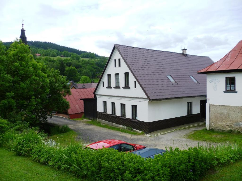 ロキトニツェ・ナト・イゼロウにあるPenzion Pod Studenovemの白屋の前に停められた赤い車