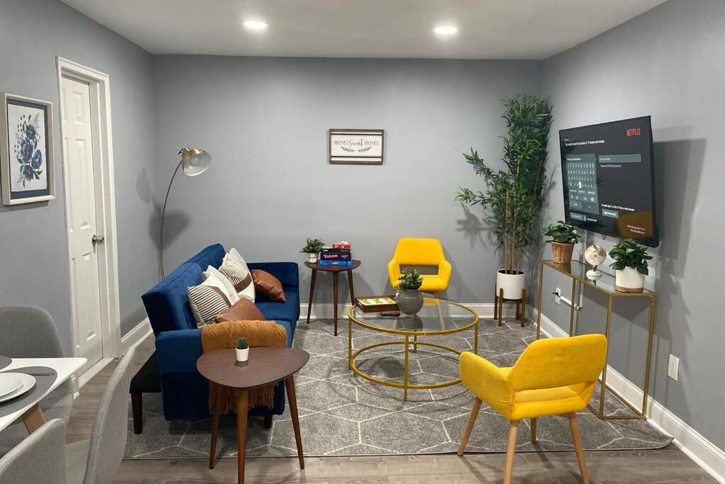 a living room with a blue couch and yellow chairs at Luxury Meets Convenience! Near NYC & EWR Airport in Lodi