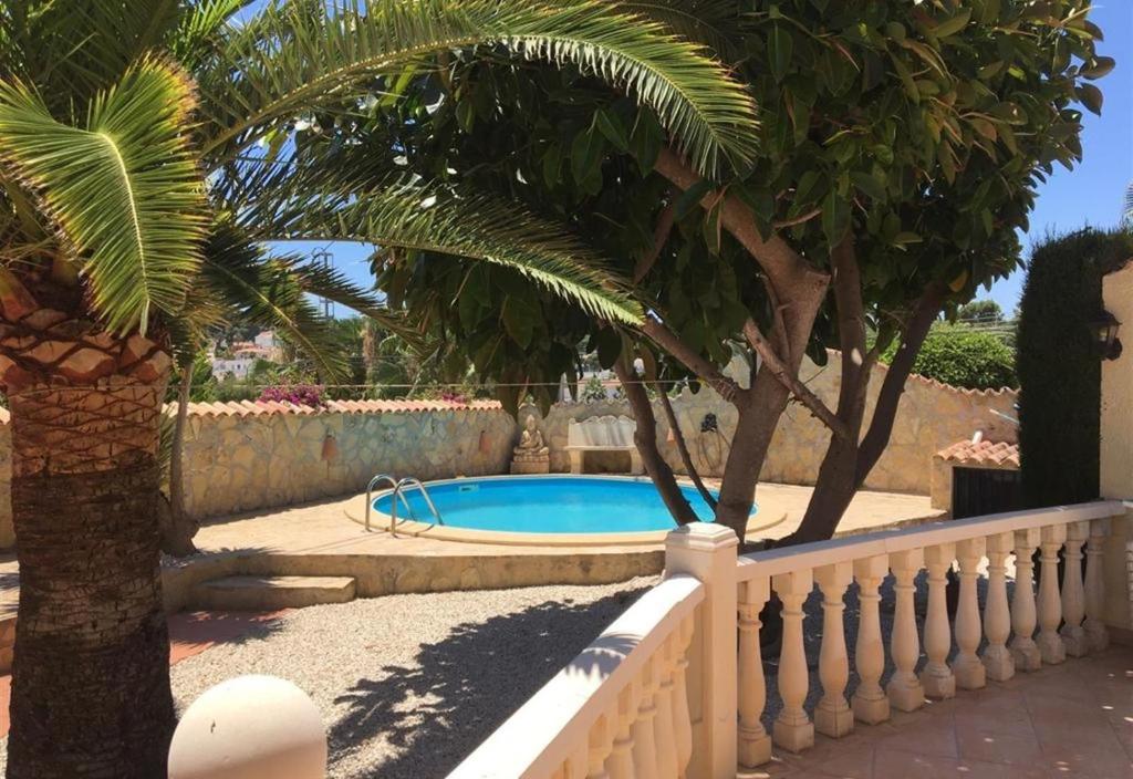 einen Pool in einem Garten mit einem Zaun und Bäumen in der Unterkunft Casa Don Fernando in Moraira