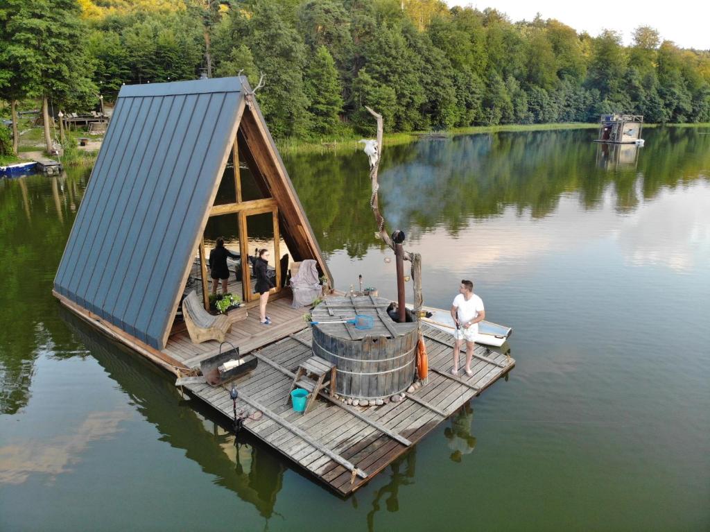 a small house on a dock on a lake at Pływająca Brda in Przywidz