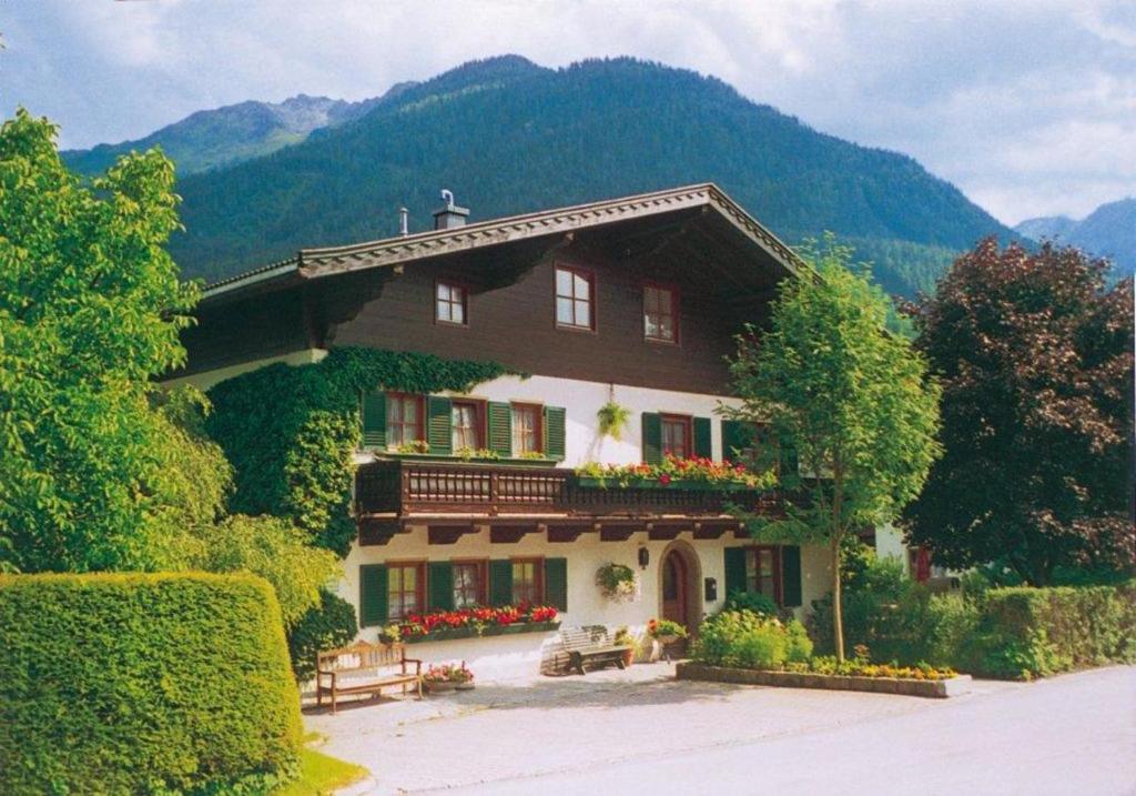 a large house with flowers in front of a mountain at Apartments Röck in Neukirchen am Großvenediger