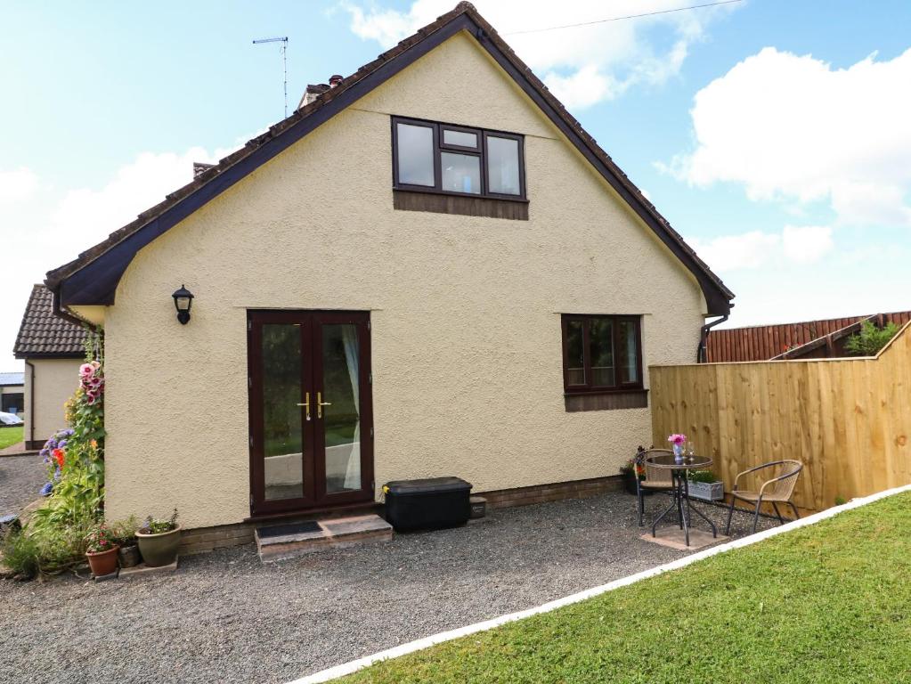 una casa blanca con ventanas negras y una valla en Buckland Farm Studio, en Watchet