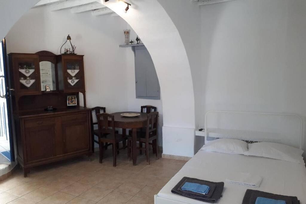 una camera con letto e tavolo con sedia di Antigonis traditional house in lefkes village a Lefkes