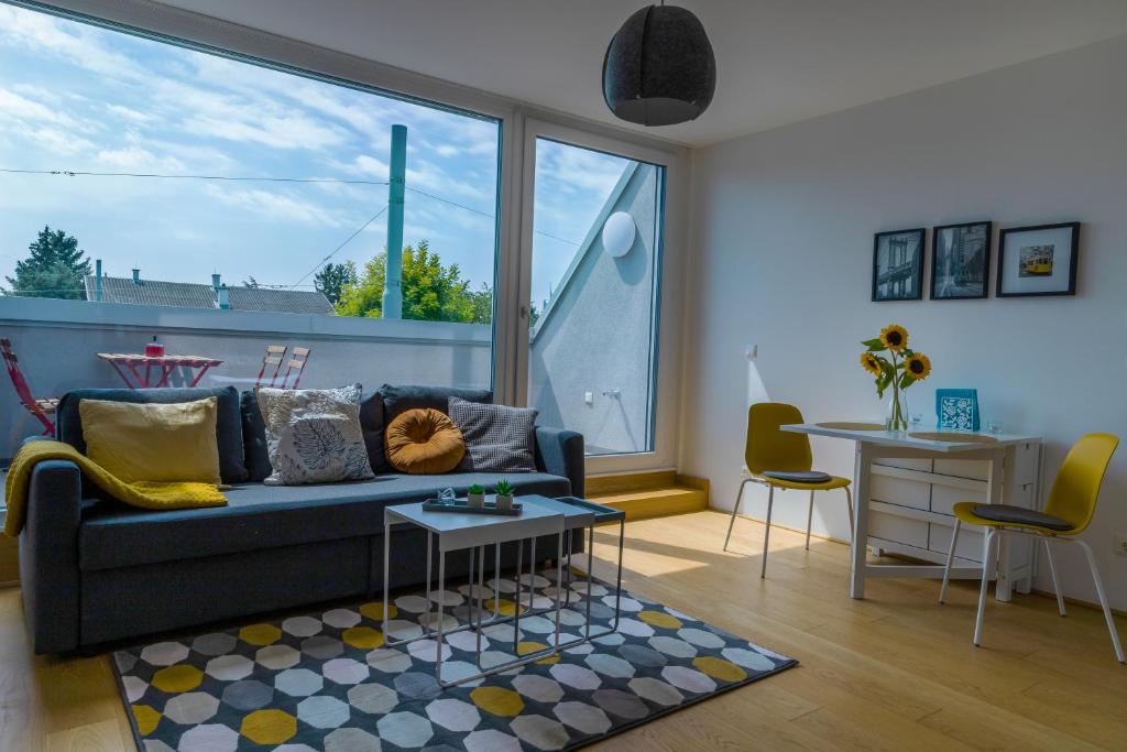 un salon avec un canapé et une grande fenêtre dans l'établissement Maureen Lovely 2 Bedroom Unit with Community Pool, à Vienne