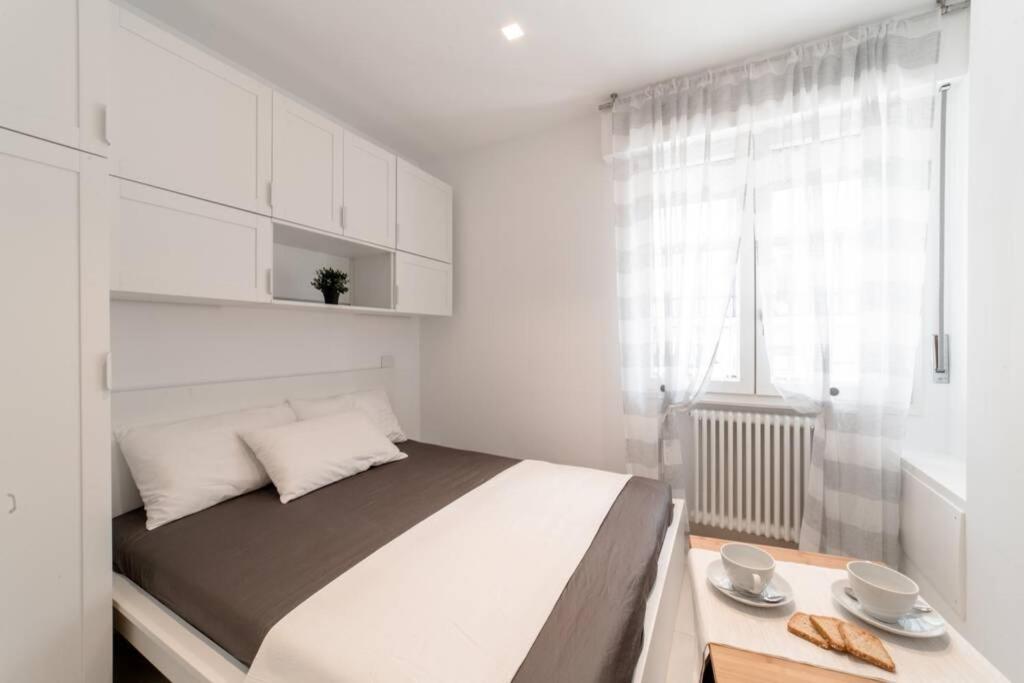 ein weißes Schlafzimmer mit einem großen Bett und einem Fenster in der Unterkunft NUOVO LOFT al MARE con PARCHEGGIO GRATUITO in Misano Adriatico