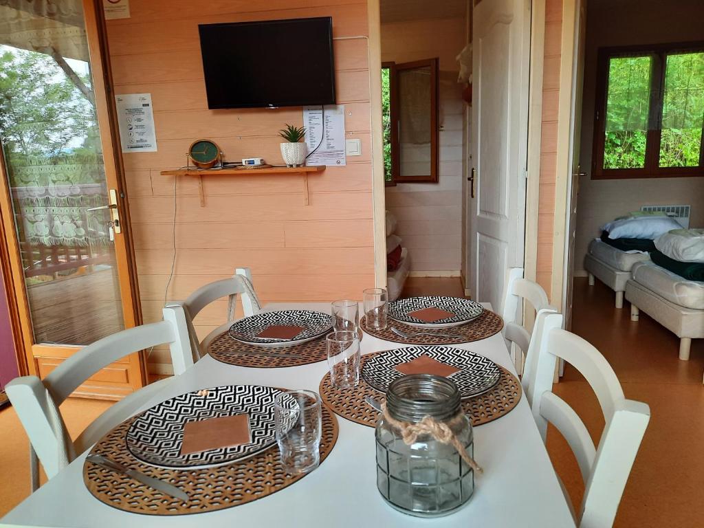 two tables with plates and glasses on top at Camping de la Bageasse in Brioude