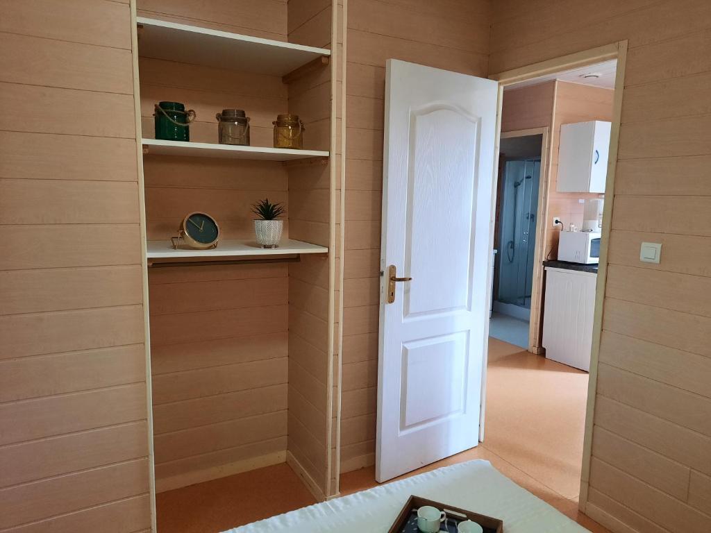 a room with a white door and a kitchen at Camping de la Bageasse in Brioude
