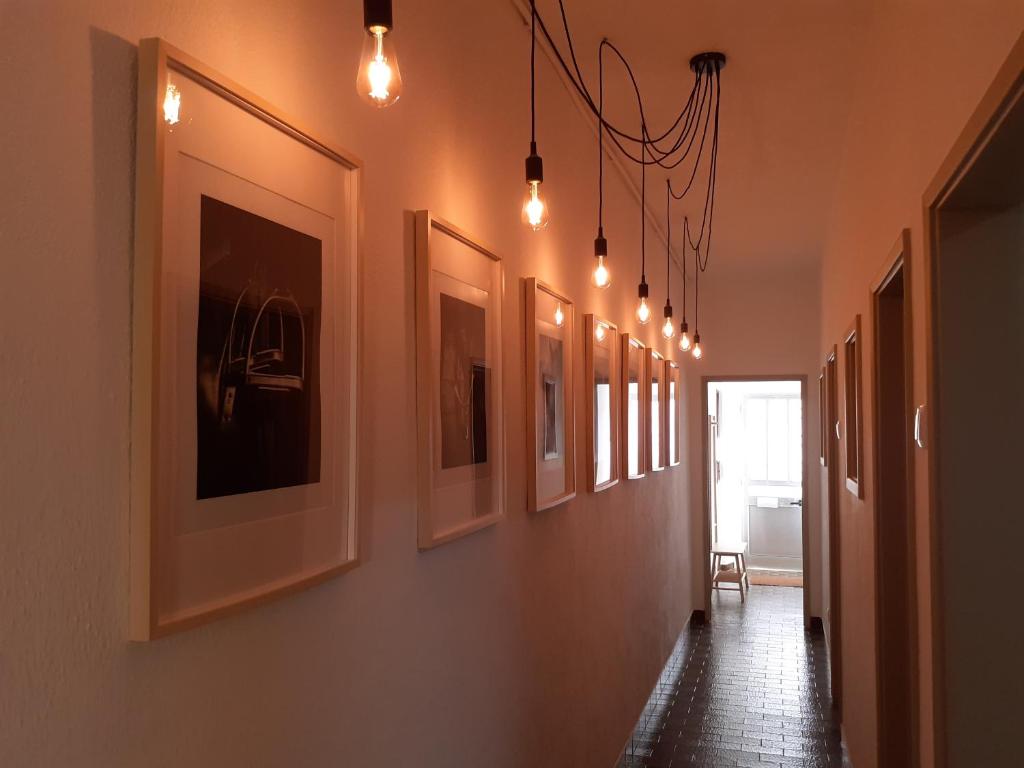 un couloir avec quelques photos sur le mur dans l'établissement Casa Encantada - Golegã, à Golegã