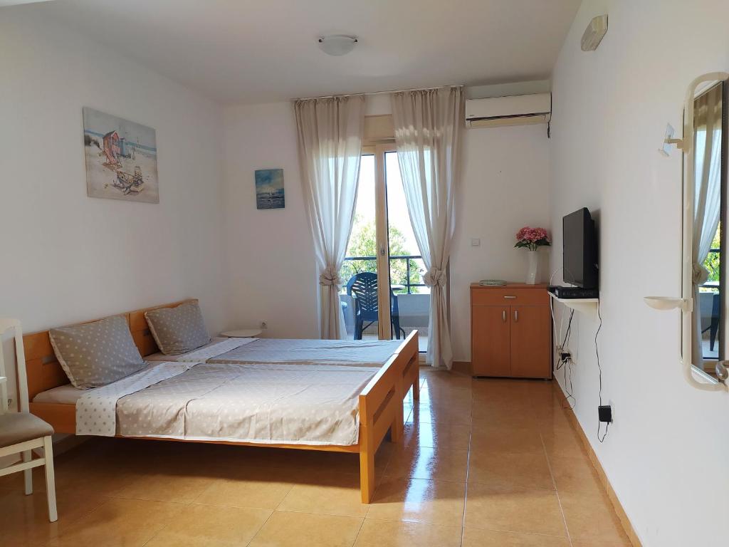 a bedroom with a bed and a couch and a television at Sunny Bay Apartments in Španjola