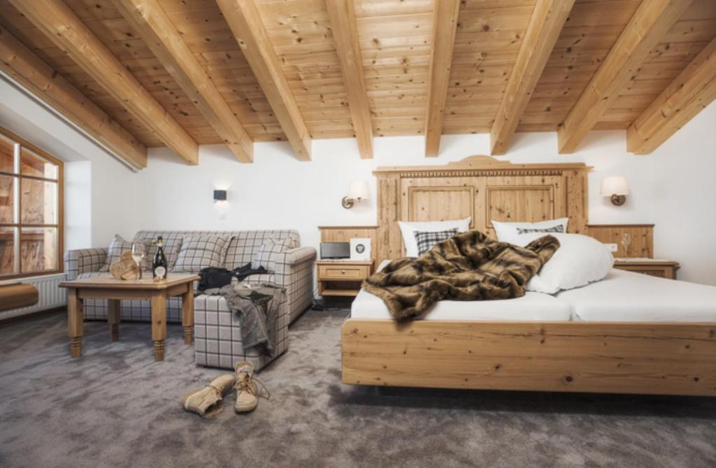 una camera con un grande letto e un divano di Kristallhütte a Zellberg
