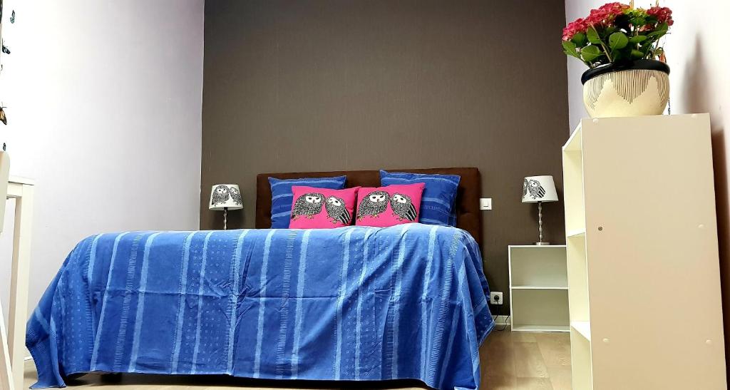 a bedroom with a blue bed with two pink pillows at Butterfly Bedroom in Sweet Home in Aimargues