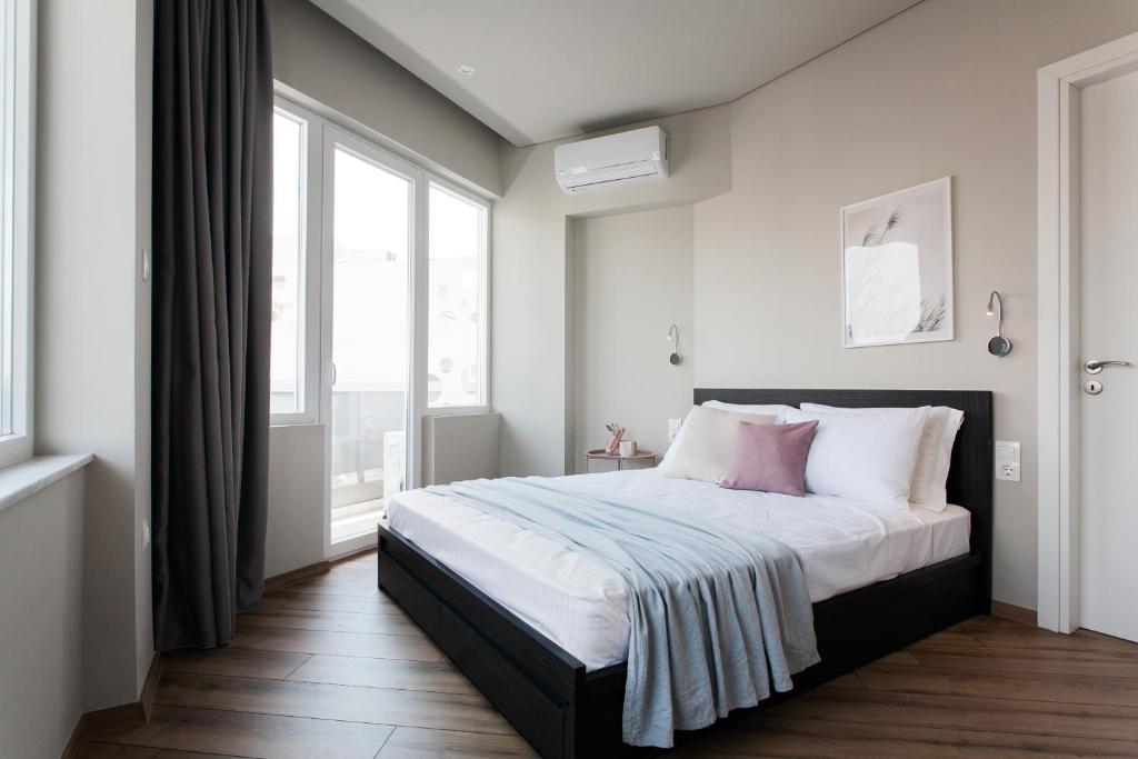 アテネにあるWYZ Athens Apartments by UPSTREETのベッドルーム1室(白とピンクの枕が備わるベッド1台付)