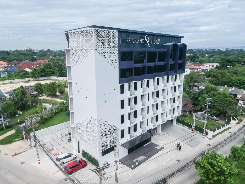 a large white building with a sign on it at SR Grand Hotel Chiangmai in Chiang Mai