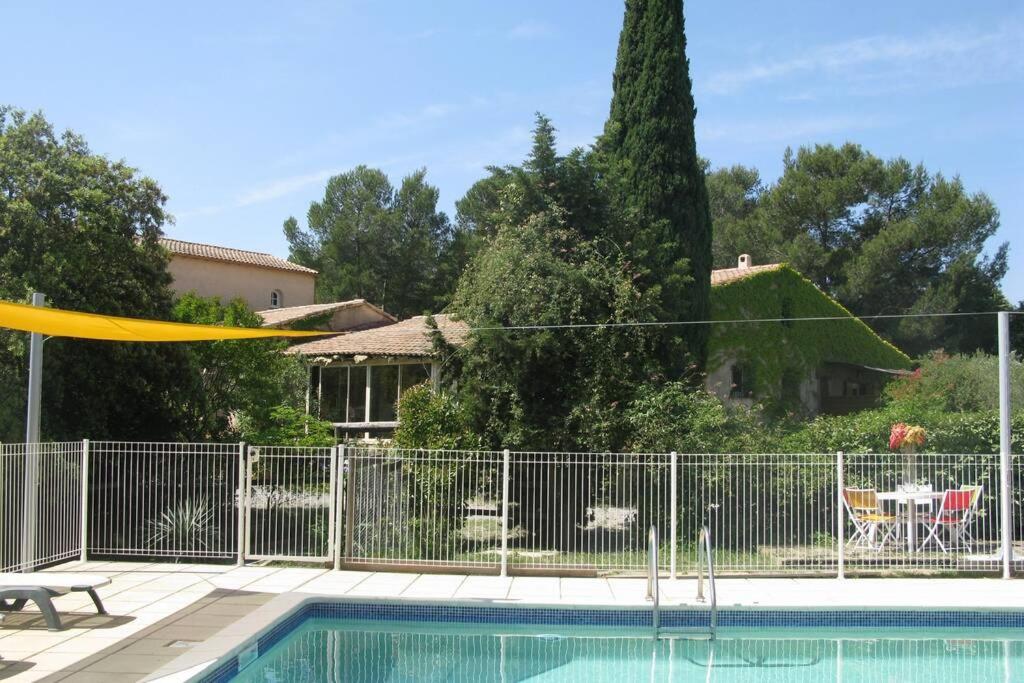 una piscina con valla y una casa en Gîte avec piscine et climatisation, en Buzignargues