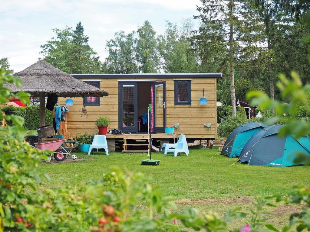 uma pequena casa e tendas num quintal em Camping Het Vossenhol em Ermelo