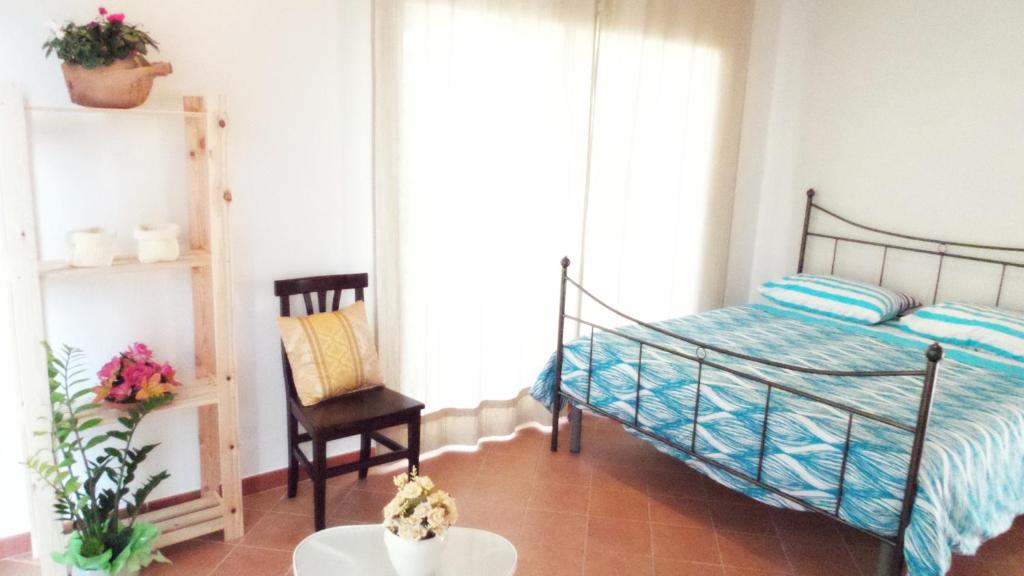 1 dormitorio con 1 cama, 1 silla y 1 mesa en B&B La Greka, en Condofuri