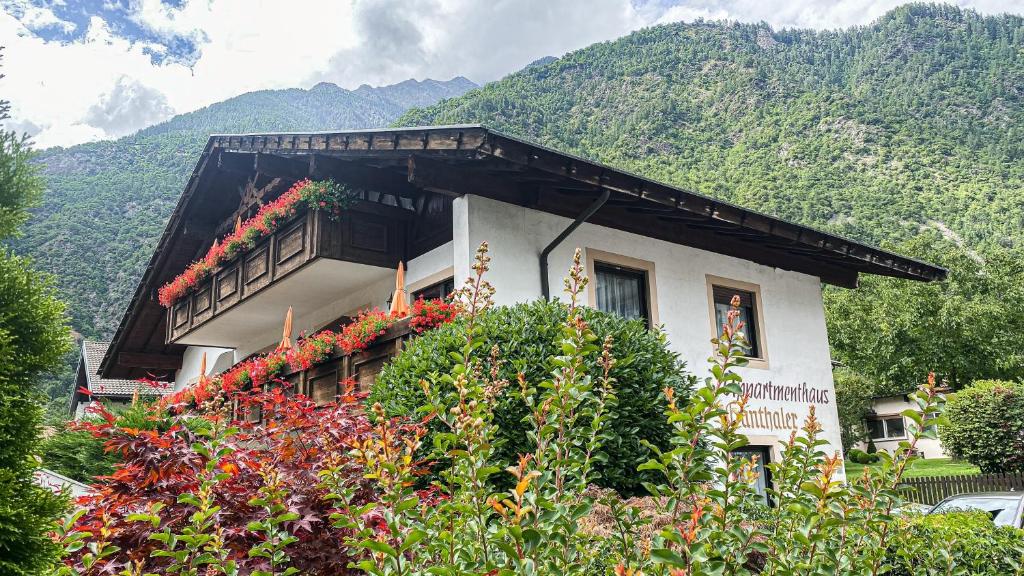 un edificio con flores frente a una montaña en Appartements Residence Ganthaler en Rablà