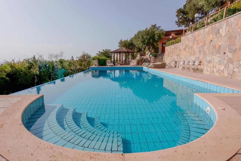 een groot zwembad met blauwe tegels op een muur bij Cedri 14 in Capitana