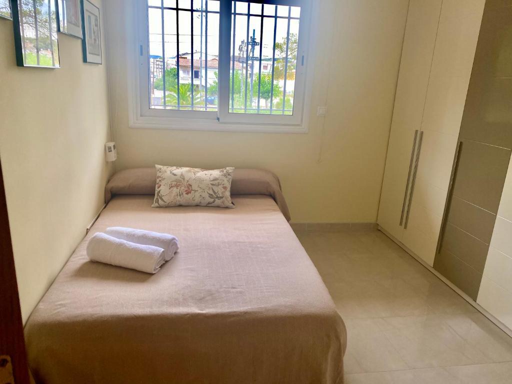 Habitación pequeña con cama con almohada. en Apartamento completo frente al mar, en Creixell