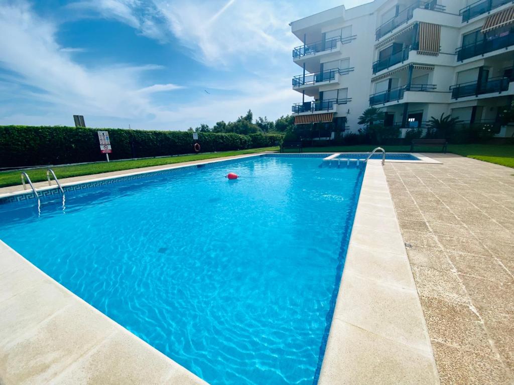 una piscina frente a un edificio en Apartamento completo frente al mar, en Creixell