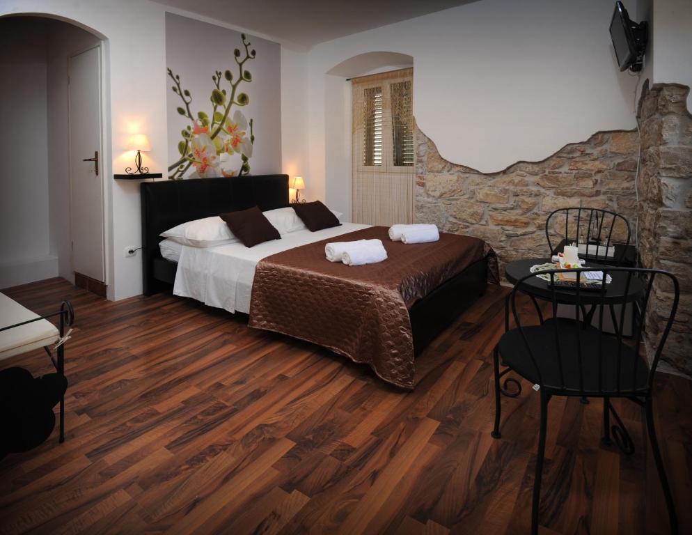 a bedroom with a large bed and a stone wall at Rooms & Apartment Lasta in Split