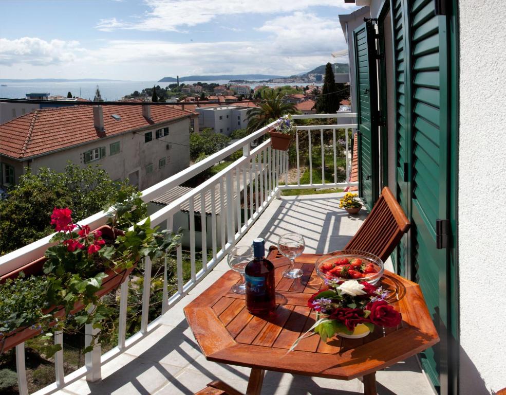 uma mesa numa varanda com uma garrafa de vinho em Apartment Firule Sandy Beach em Split