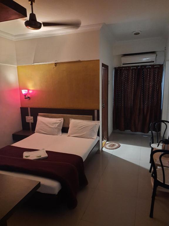 Habitación de hotel con cama y ventana en HOTEL S K PALACE, en Mahabaleshwar