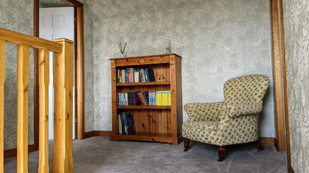 a room with a chair and a book shelf at Remuera, North Tolsta in North Tolsta