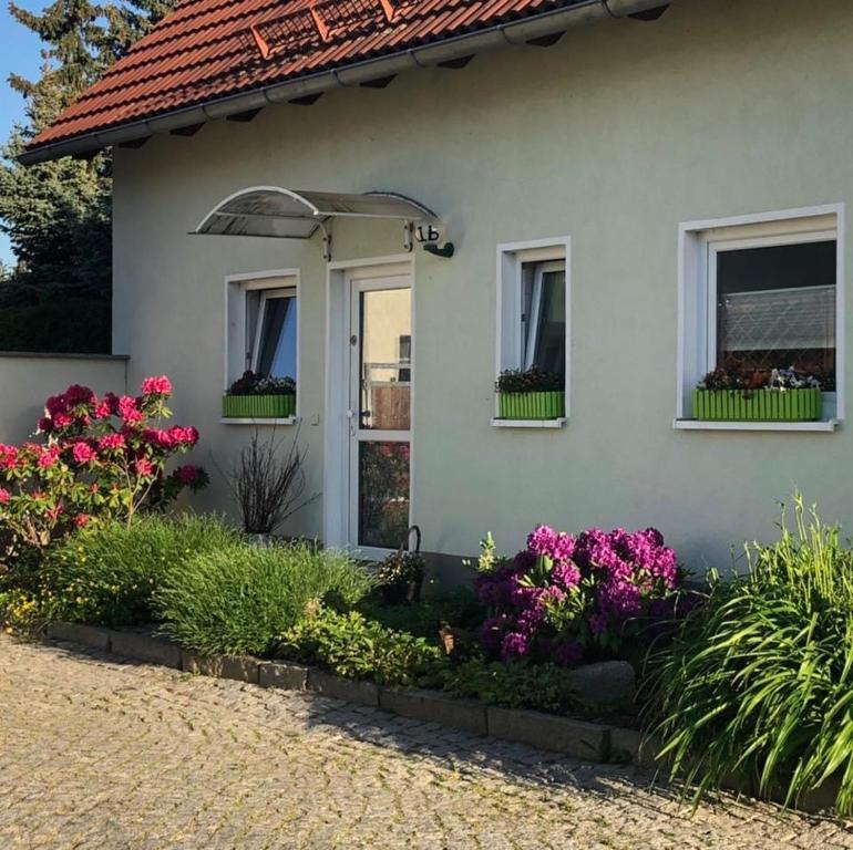 ein weißes Haus mit Blumen davor in der Unterkunft Ferienhaus Zur Heide - Obergeschoss in Radibor