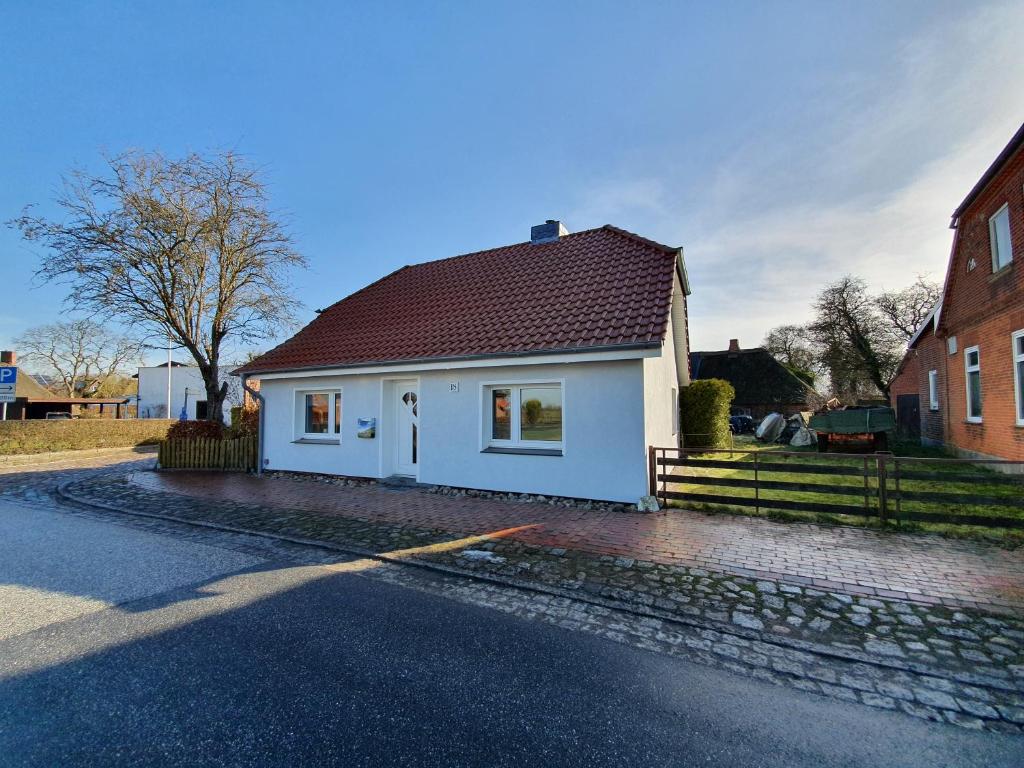 a white house with a red roof on a street at Ostssespitze in Riepsdorf