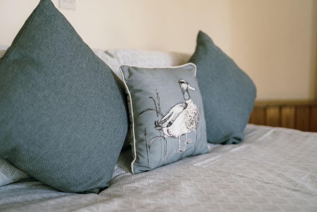 a bed with blue pillows with a bird on it at Beachborough Park in Folkestone
