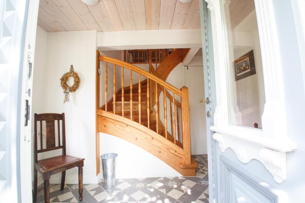 a hallway with a wooden staircase in a house at Oevenum Vogelkoje in Oevenum OG in Oevenum