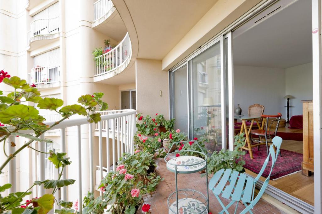 balcón con mesa, sillas y flores en L'appart Beaubadat, en Burdeos