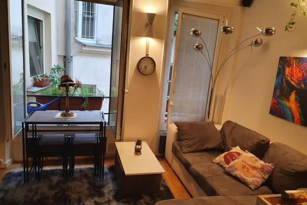 un salon avec un canapé et une table dans l'établissement Cozy apt Heart of Paris, 3 mins Louvre, à Paris