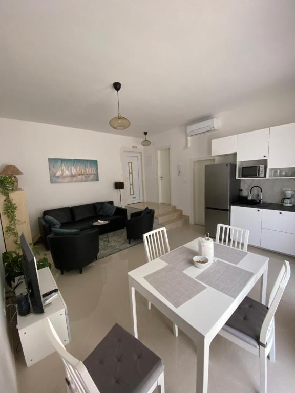 a kitchen and a living room with a table and chairs at Hygge Apartments in Mokošica