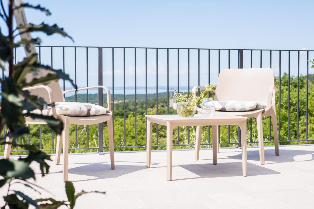 two chairs and a table on a balcony at Encanto Agriturismo & Private SPA in Visogliano