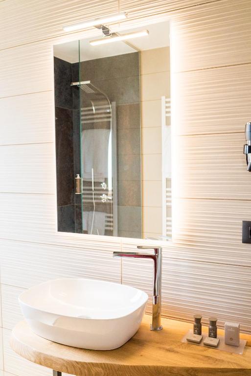 a bathroom with a white sink and a mirror at Encanto Agriturismo & Private SPA in Visogliano