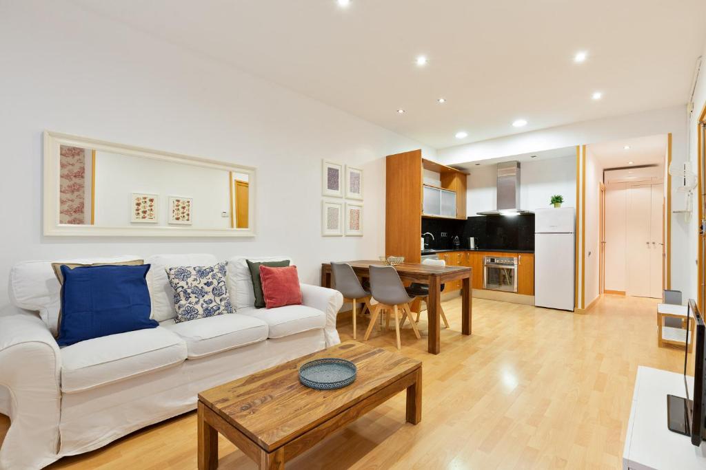 sala de estar con sofá blanco y mesa en Stay U-nique Apartments Terrassa, en Barcelona