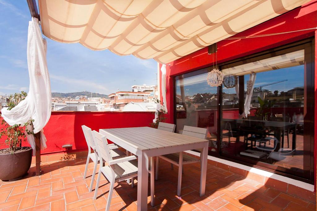 una mesa y sillas en un balcón con una pared roja en Stay U-nique Apartments Sagues, en Barcelona