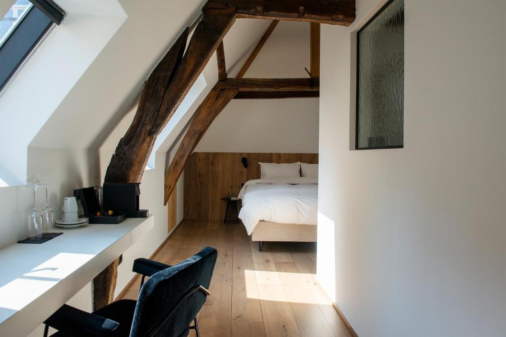 a bedroom with a bed and a desk and chairs at Hotel Riga in Antwerp