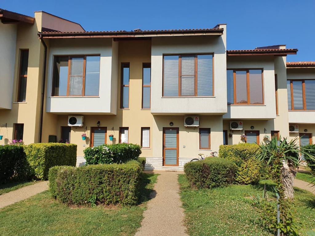 a house with bushes in front of it at Golf Villa in Lighthouse Golf & SPA Resort in Balchik