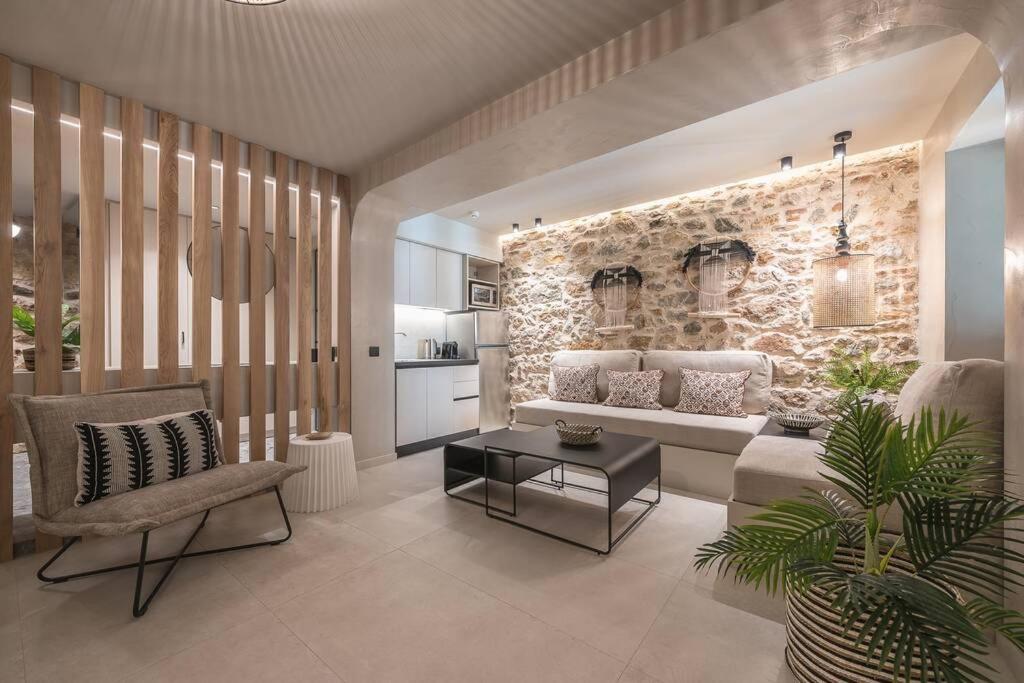 a living room with a couch and a stone wall at Apollonos 28 Luxury Suites in Athens