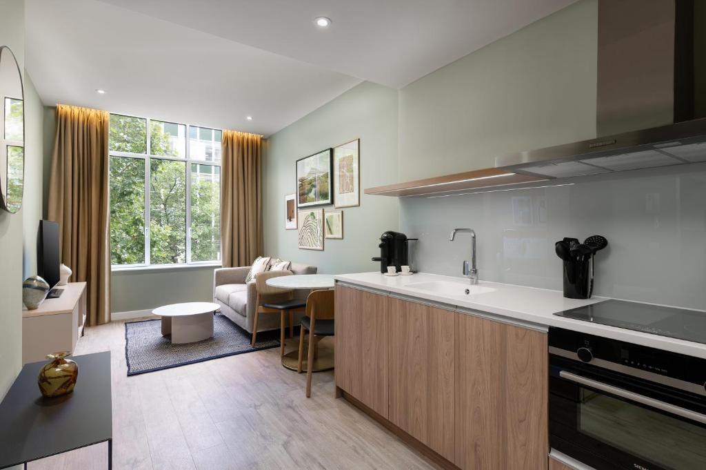 a kitchen with a counter and a living room at The Lincoln Suites in London