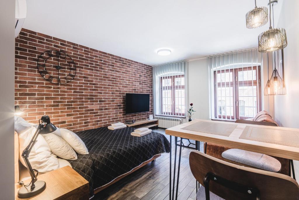 Televízia a/alebo spoločenská miestnosť v ubytovaní Apartamenty Świętego Jakuba