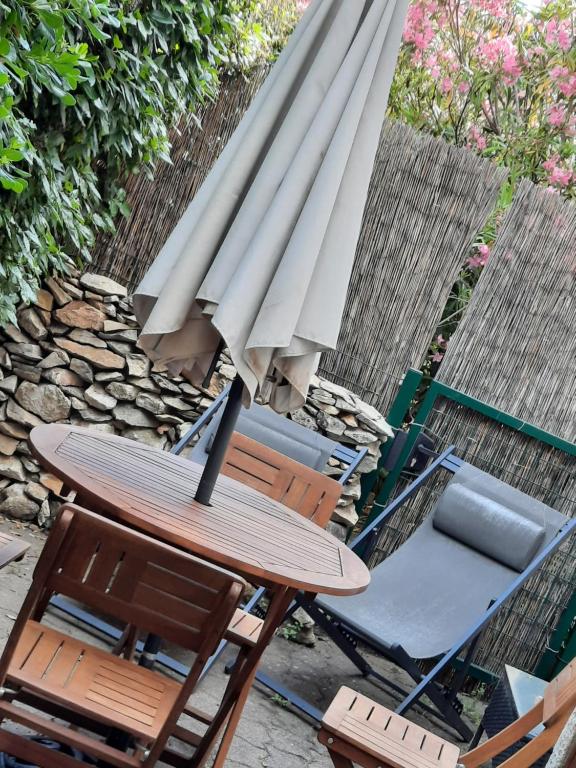 une table et des chaises avec un parapluie et une planche de surf dans l'établissement Coquet T2 ,terrasse,parking ,4 kms d Avignon, à Villeneuve-lès-Avignon
