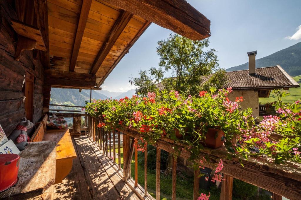 Un balcón de una casa con flores. en Ferienhaus Weierhof en Moso